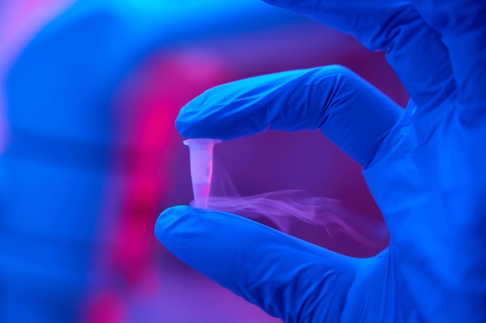 Laboratory assistant in protective gloves holds a small test tube